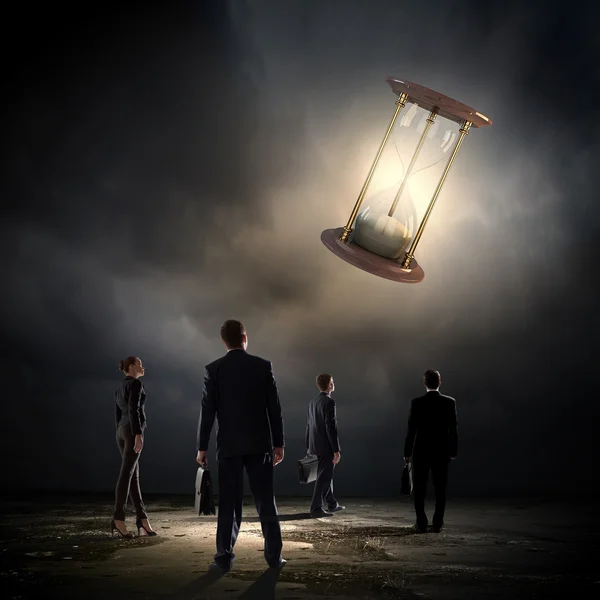 Business people looking at sandglass — Stock Photo, Image