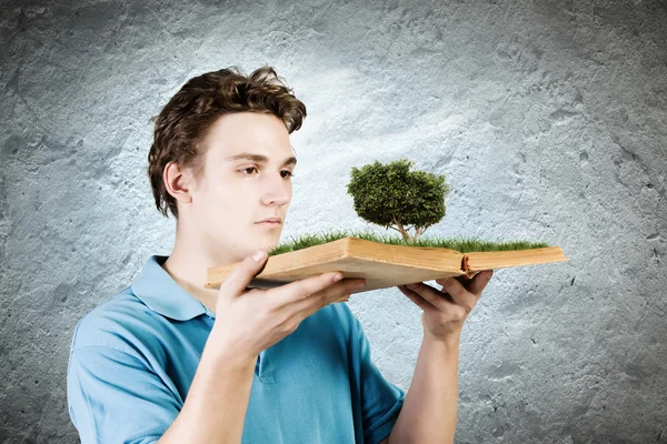 Homem segurando livro com árvore verde — Fotografia de Stock