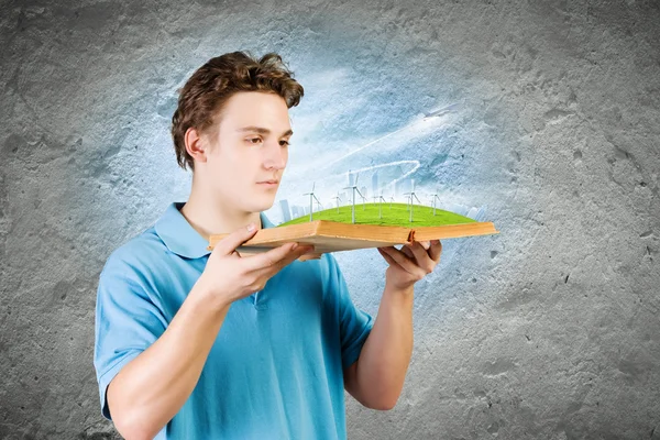 Mann hält Buch mit Windmühlen — Stockfoto