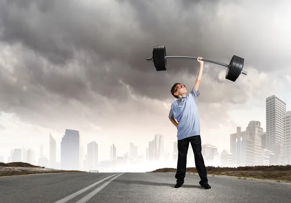 Boy lifting barbell above head — Stock Photo, Image