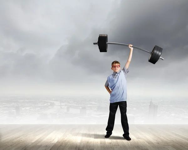 Boy lifting barbell above head — Stock Photo, Image