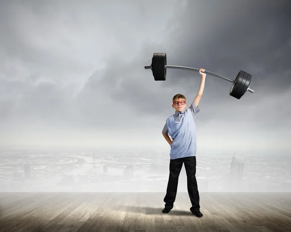 Boy lifting barbell above head — Stock Photo, Image