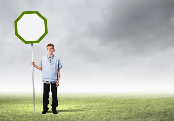 Boy holding blank road sign — Stock Photo, Image