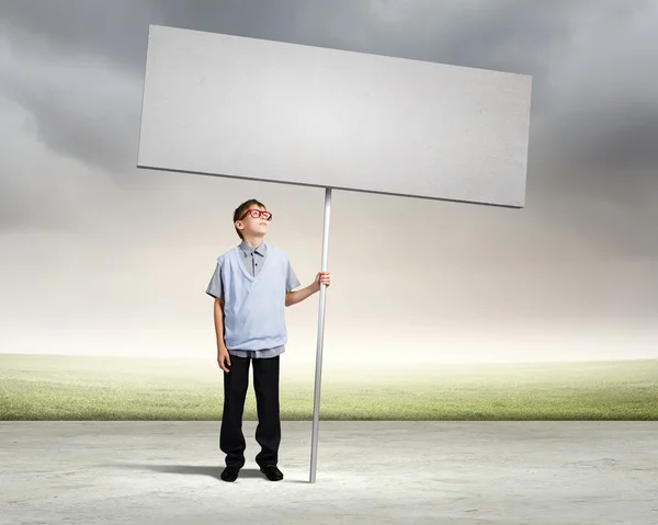 Menino segurando banner em branco — Fotografia de Stock