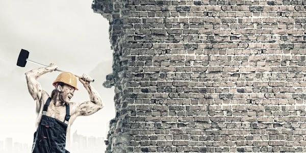 Man breaking wall with hammer — Stock Photo, Image