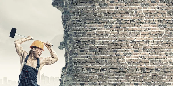 Hombre rompiendo pared con martillo — Foto de Stock