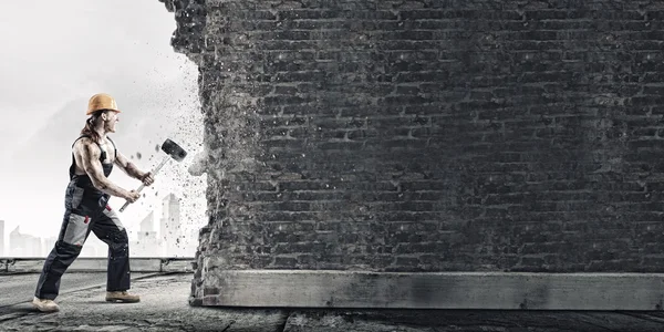 Man breaking wall with hammer — Stock Photo, Image