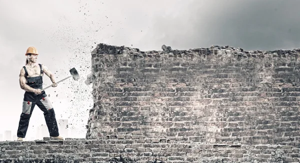 Hombre rompiendo pared con martillo — Foto de Stock