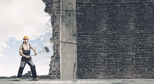 Man breaking wall with hammer — Stock Photo, Image