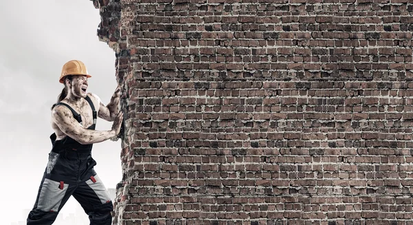 Strong man pushing wall — Stock Photo, Image