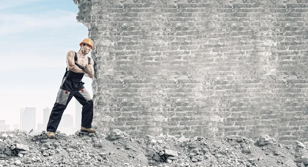 Strong man pushing wall — Stock Photo, Image