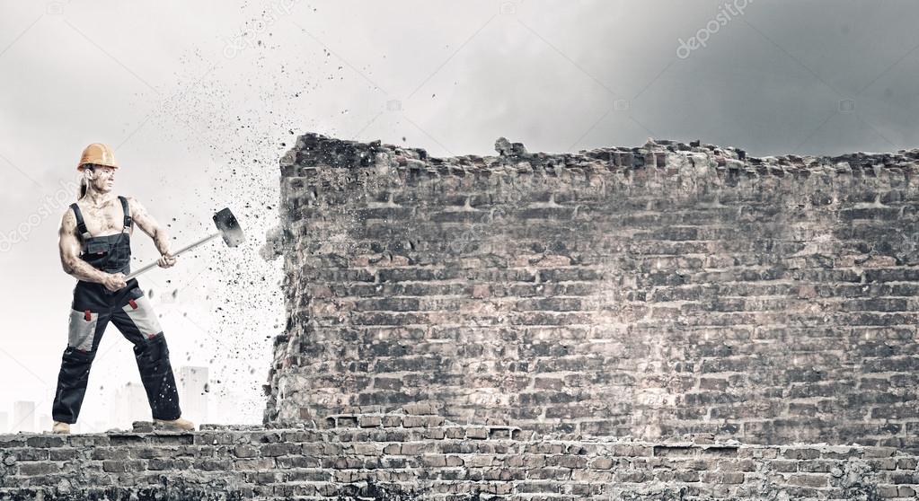 Man breaking wall with hammer