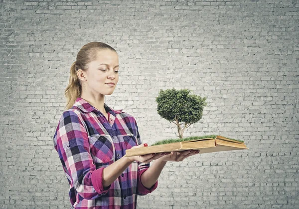 Frau hält Buch mit grünem Baum — Stockfoto