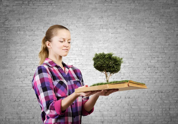 Woman holding book with green tree — Stock Photo, Image