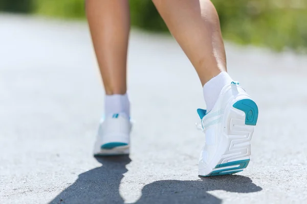 Pies femeninos corriendo por carretera — Foto de Stock