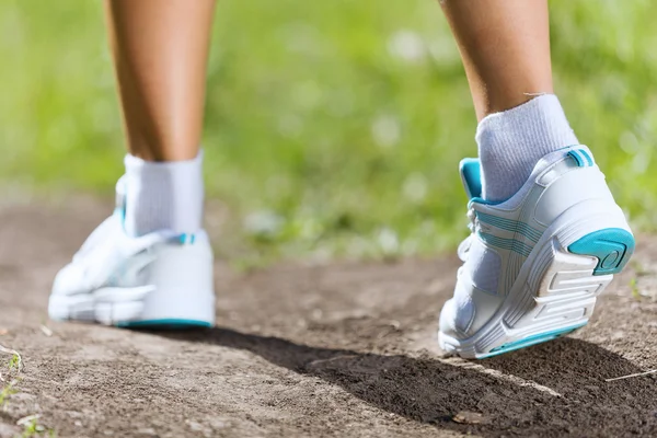 Pieds féminins courant sur la route — Photo