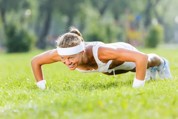 Sport girl doing push ups — Stock Photo, Image