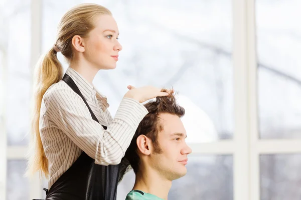 Молодой мужчина и женщина парикмахер — стоковое фото