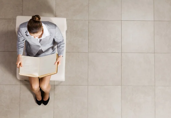 Businesswoman livro de leitura na cadeira — Fotografia de Stock