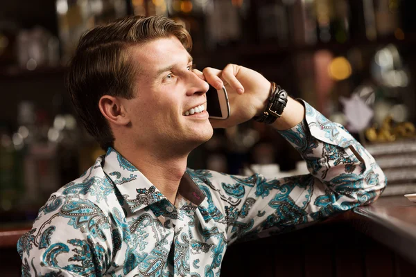 Man talking on phone at bar — Stock Photo, Image