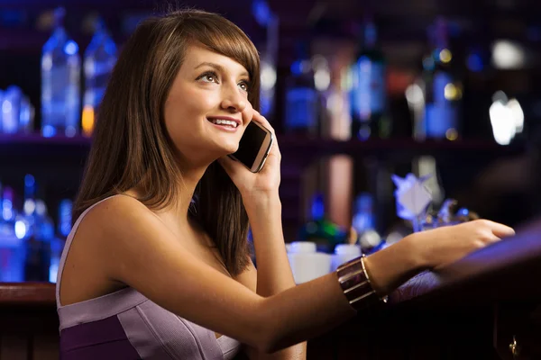 Lady at bar talking on phone — Stock Photo, Image