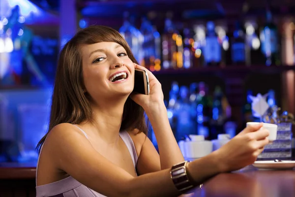 Lady at bar talking on phone — Stock Photo, Image