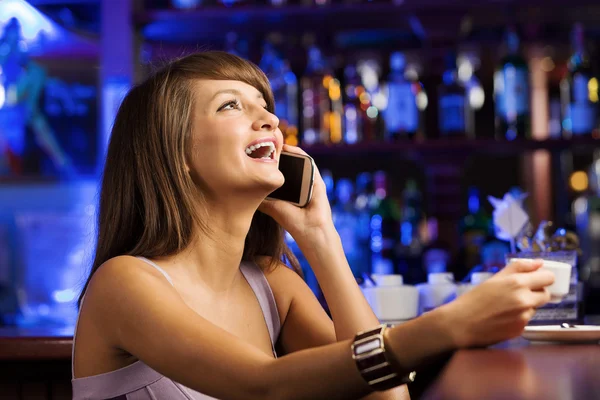 Lady at bar talking on phone — Stock Photo, Image