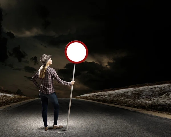 Woman holding road sign — Stock Photo, Image