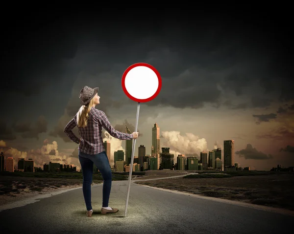 Mujer sosteniendo señal de tráfico — Foto de Stock