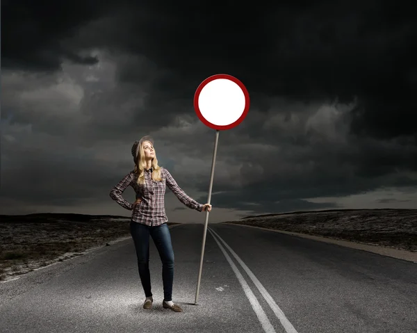 Femme tenant panneau de signalisation routière — Photo