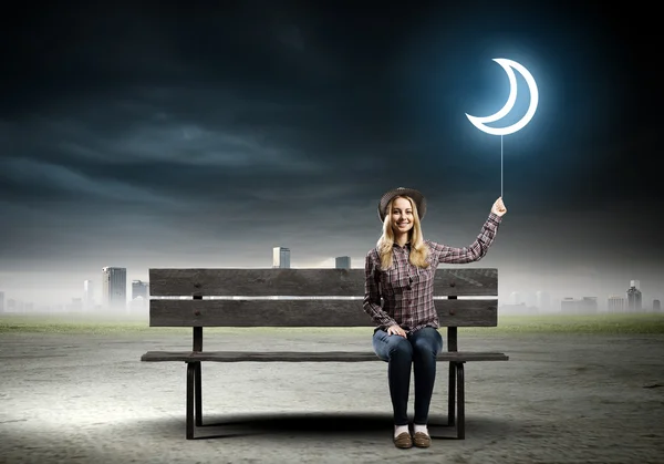 Woman sitting on bench with balloon — Stock Photo, Image