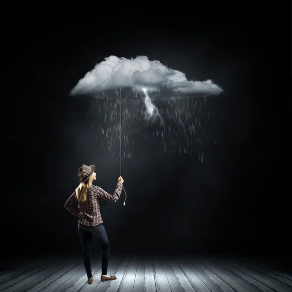 Woman holding raining cloud on rope — Stock Photo, Image