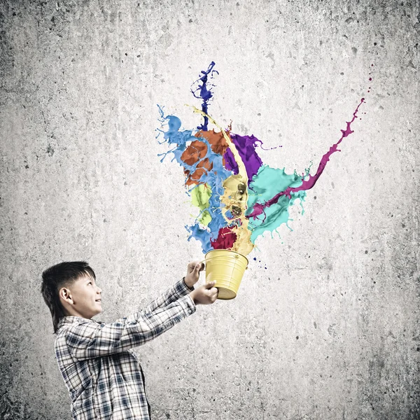 Boy splashing colorful paint — Stock Photo, Image