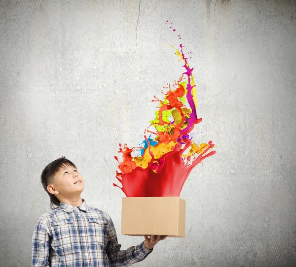 Boy splashing colorful paint — Stock Photo, Image