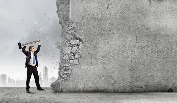 Businessman breaking cement wall — Stock Photo, Image