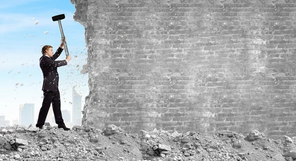 Businessman breaking cement wall — Stock Photo, Image