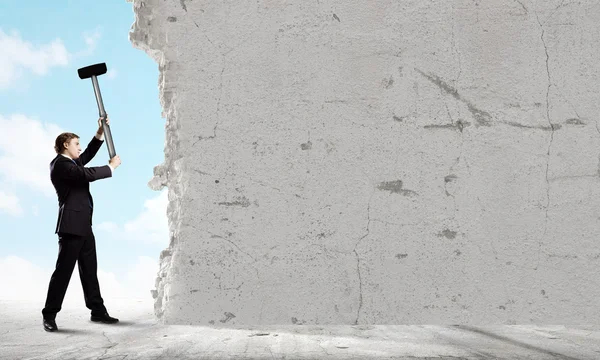 Biznesmen łamanie cementowe ściany — Zdjęcie stockowe
