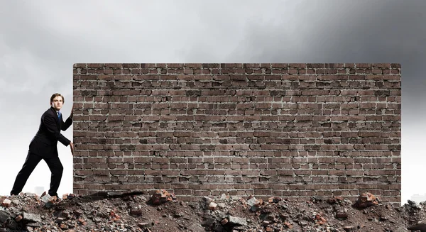 Homme d'affaires déplacer mur de briques — Photo