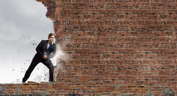 Businessman move brick wall