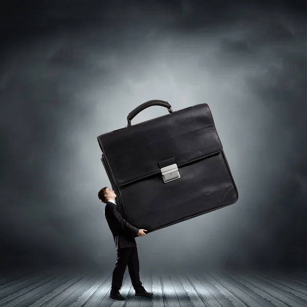 Homme d'affaires portant une valise lourde — Photo