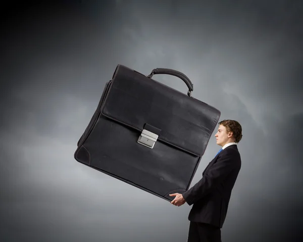 Businessman carrying heavy suitcase — Stock Photo, Image