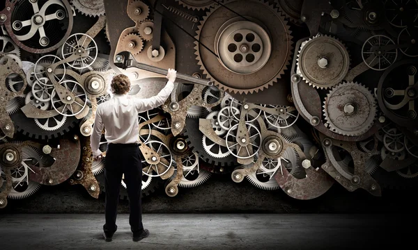 Businessman fixing gears mechanism — Stock Photo, Image