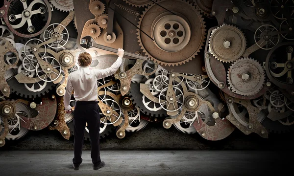 Businessman fixing gears mechanism — Stock Photo, Image