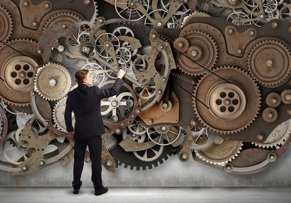 Businessman fixing gears mechanism — Stock Photo, Image