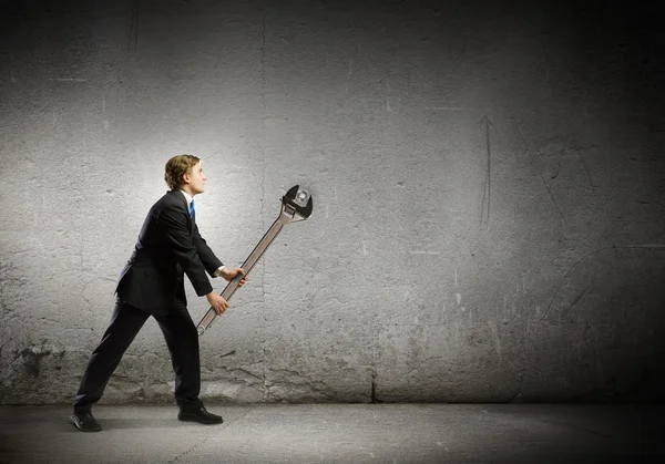 Businessman with wrench — Stock Photo, Image