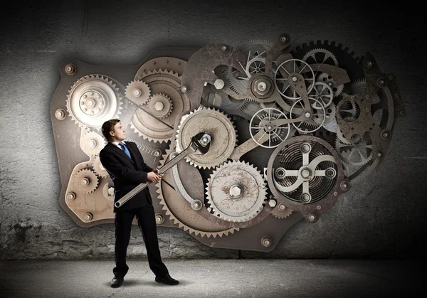 Businessman fixing gears mechanism — Stock Photo, Image