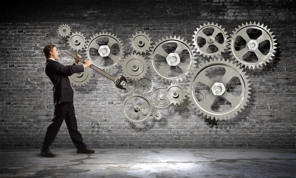 Businessman fixing gears mechanism — Stock Photo, Image