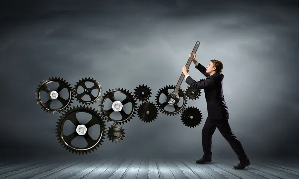 Businessman fixing gears mechanism — Stock Photo, Image