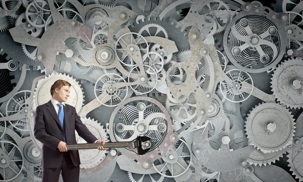 Businessman fixing gears mechanism — Stock Photo, Image