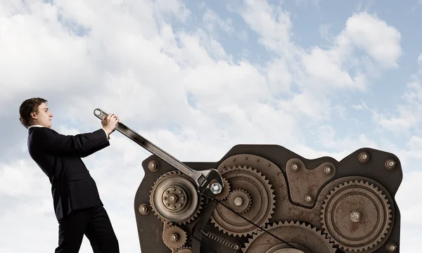 Businessman fixing gears mechanism — Stock Photo, Image